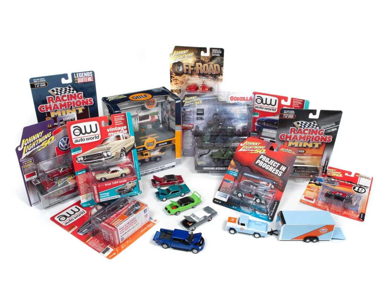 A spread of carded die-cast models from Johnny Lightning, Auto World and Racing Champions, with a few loose cars and a Gulf pickup and trailer up front